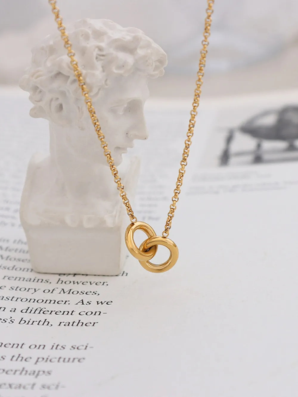 Gold interlocked circle pendant necklace with a sculptural design.