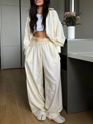Pajama set: pinstriped long sleeve button-down shirt and wide leg pants in pastel yellow with drawstring.