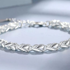 Sterling silver bracelet with interconnected heart links and a clasp closure.