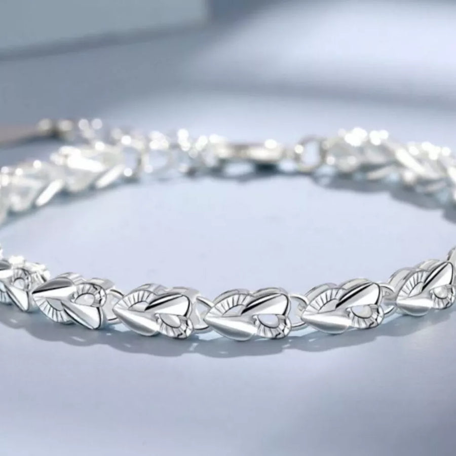 Sterling silver bracelet with interconnected heart links and a clasp closure.