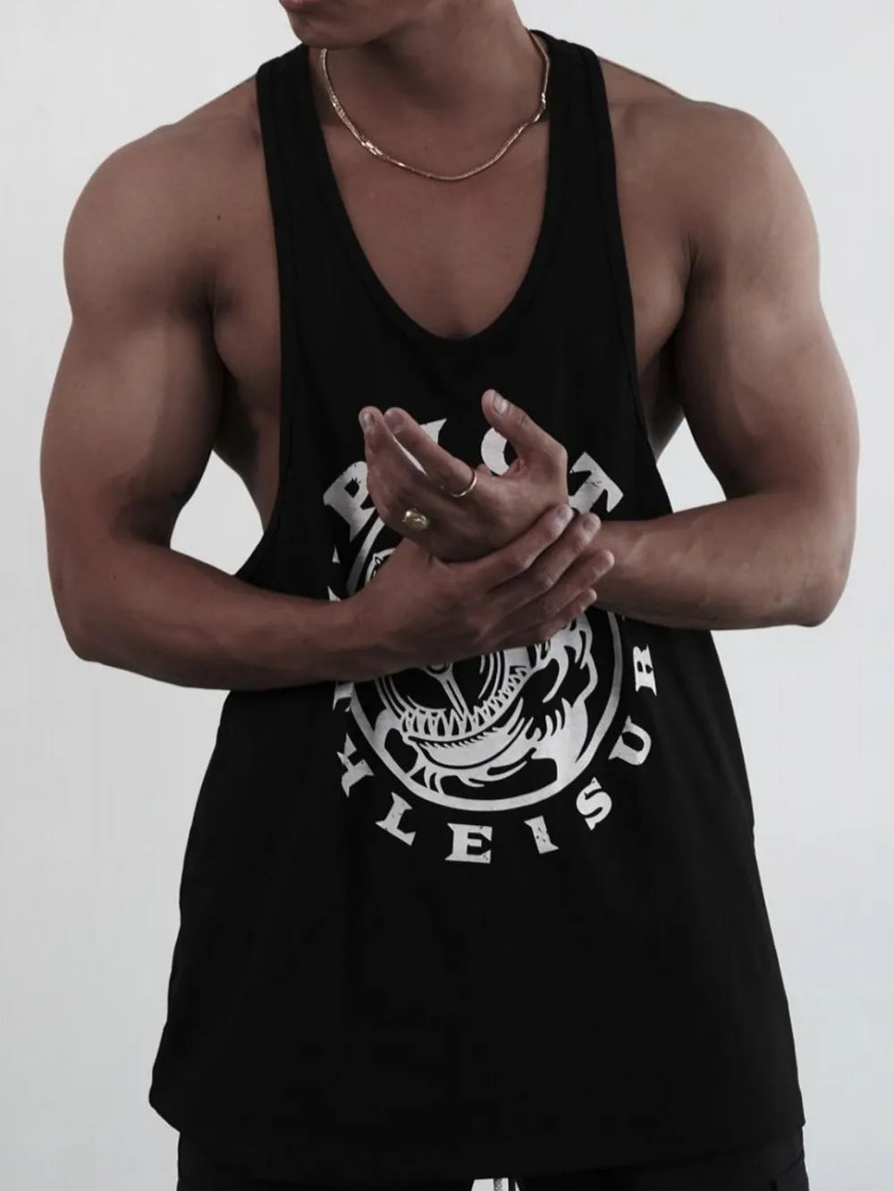 Black graphic muscle tank with racerback and bold circular logo detail.