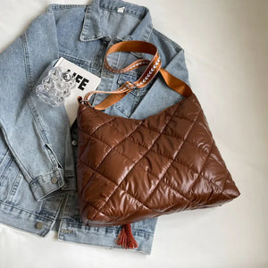 Brown diamond quilt padded shoulder bag with tassel detail and patterned strap.
