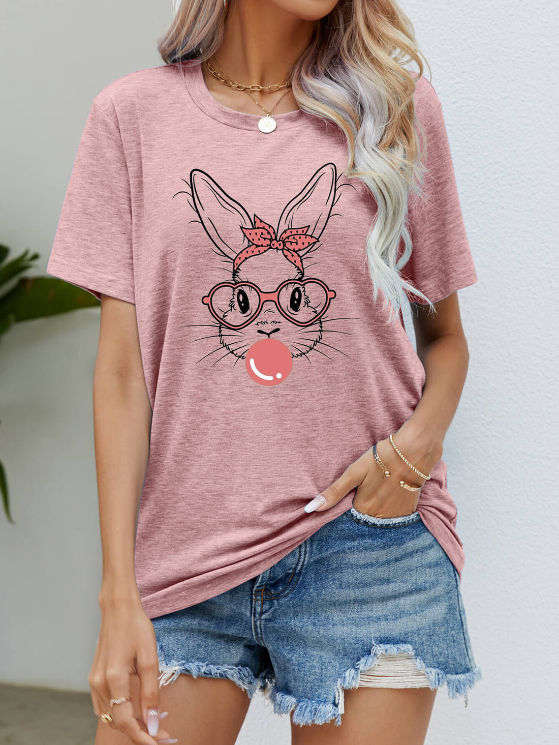 Dusty pink t-shirt with a graphic of a bunny wearing glasses and a bandana, blowing bubblegum.
