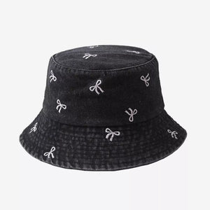 Black denim bucket hat with white embroidered bow pattern
