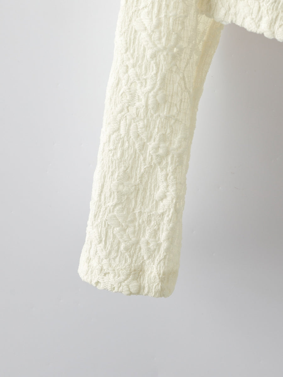Cream lace button-up cardigan with textured floral pattern detail.