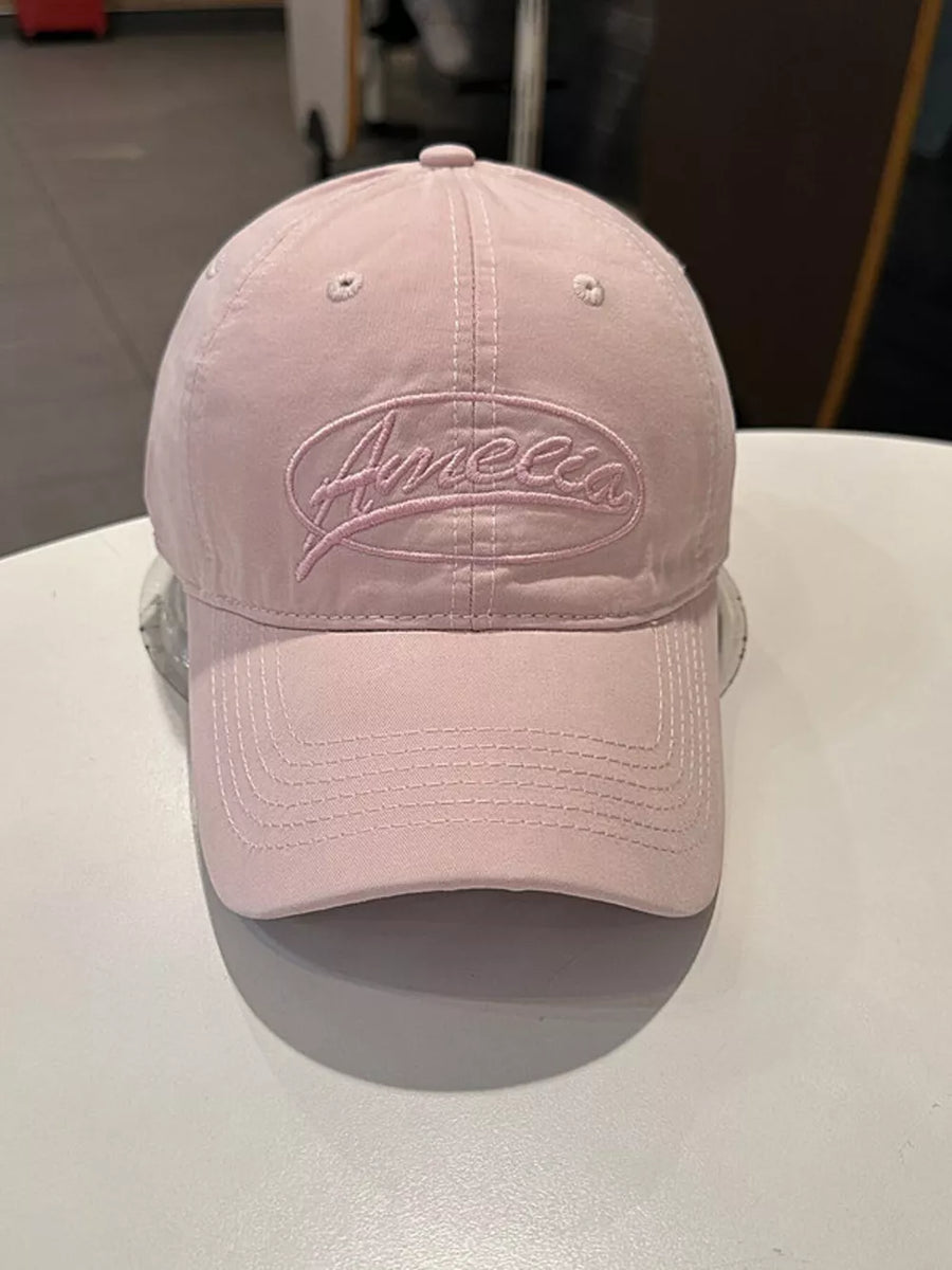 Pink baseball cap with embroidered oval logo detail and curved brim