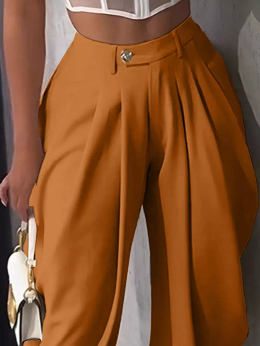 Orange high-waisted pleated pants with button closure and wide leg.