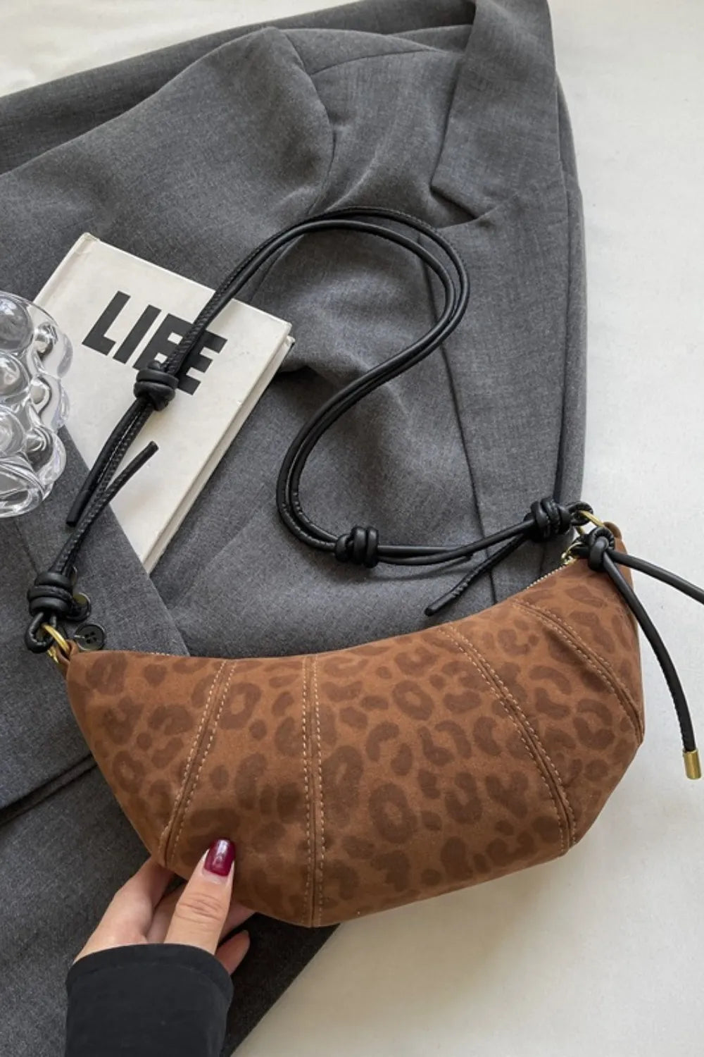 Brown leopard print crescent shoulder bag with knot detail and black strap