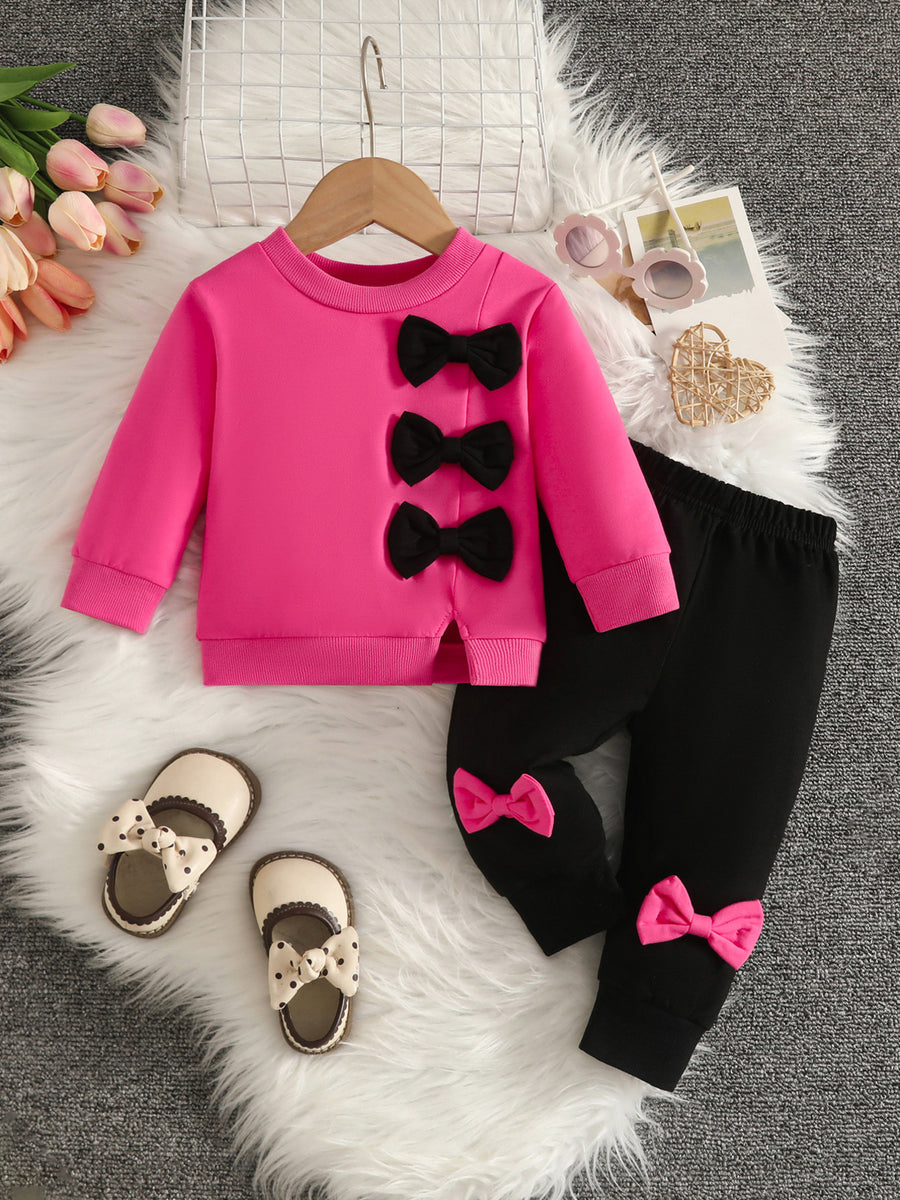 sweatshirt and pants set in hot pink featuring bows and relaxed fit