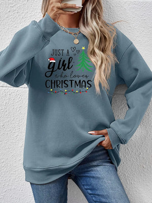 Misty Blue sweatshirt with "Just a girl who loves Christmas" graphic and Christmas lights.