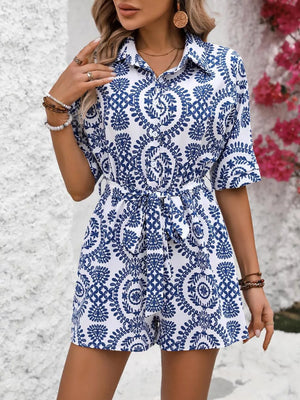 Blue and white printed tie-waist romper with short sleeves and a collared neckline.