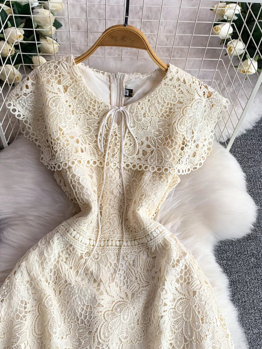 Cream lace A-line dress with short sleeves, round neckline, and tie detail.