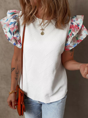 White knit top with floral ruffled sleeves and a textured chevron pattern.