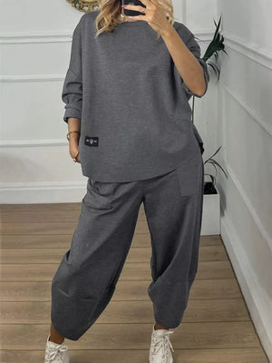 Dark gray crew neck two-piece lounge set with relaxed fit pants and a long sleeve top.