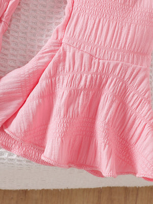 Pink cotton blend baby top with smocked bodice and ruffled hem detail