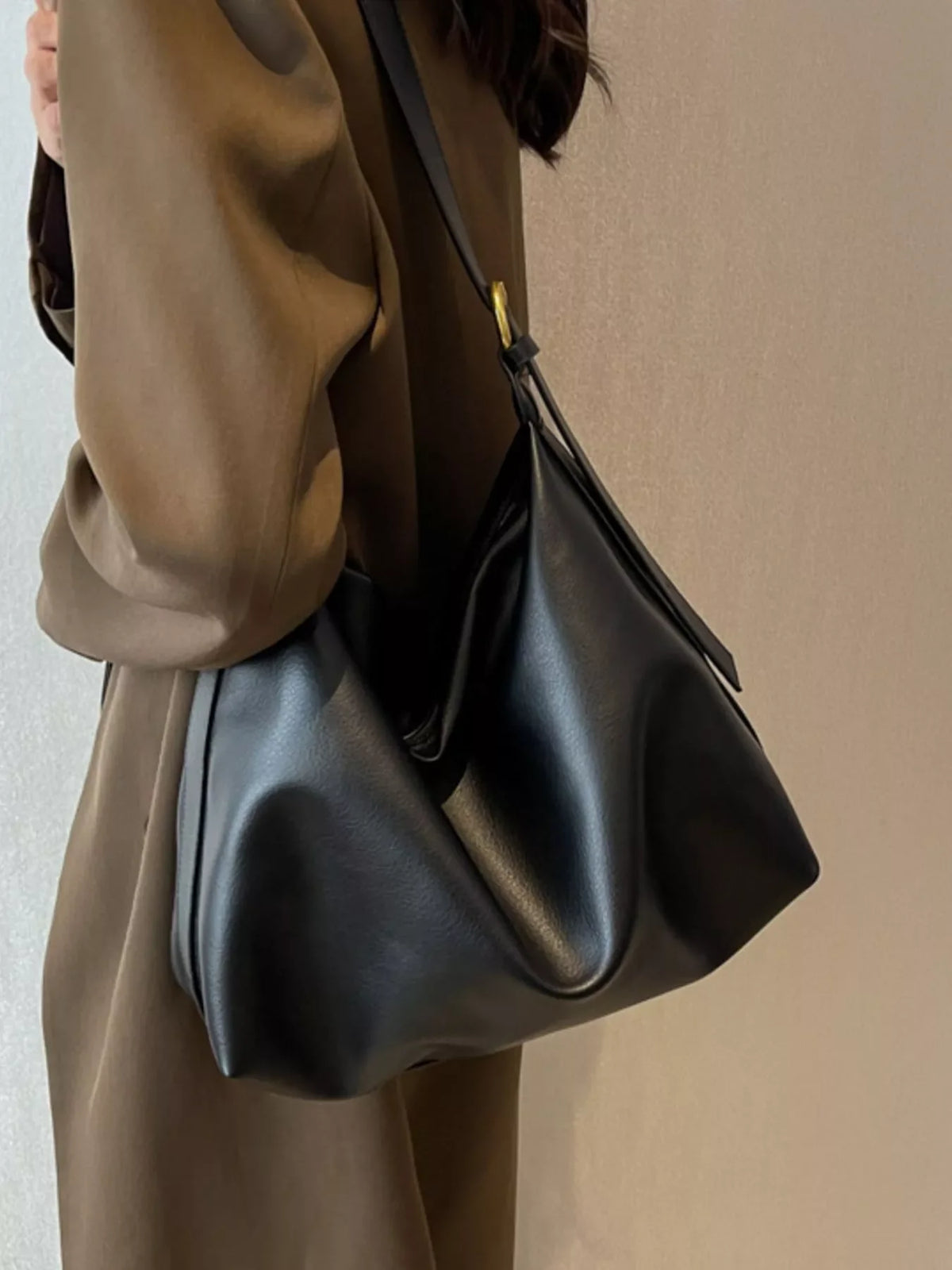 Black sculptural PU leather shoulder bag with adjustable strap