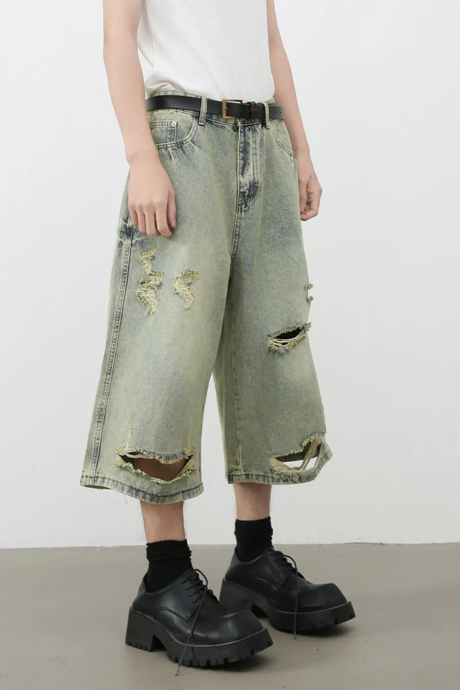 Distressed culotte denim shorts in medium wash with ripped details and a wide leg.