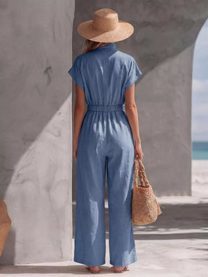 Blue wide-leg maternity jumpsuit with short sleeves and elastic waist, shown from the back.