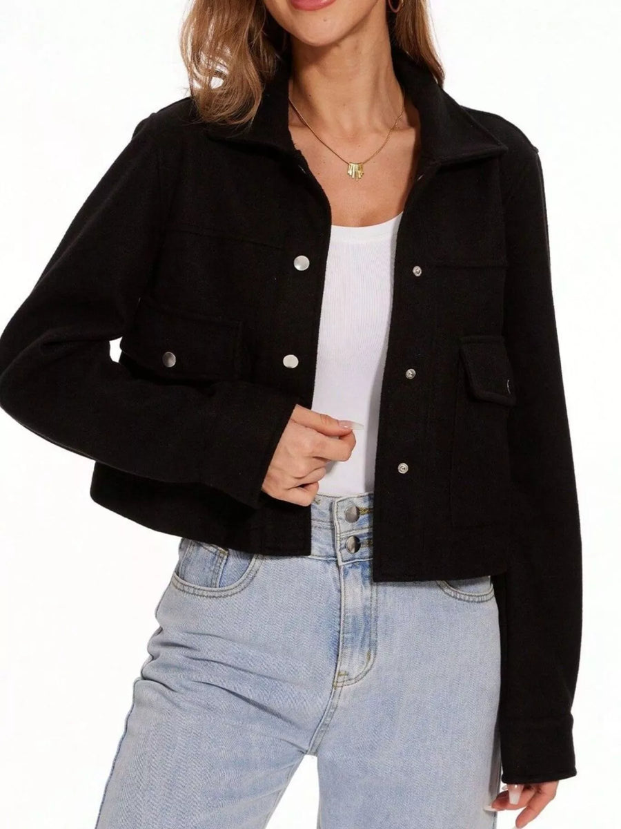 Black trucker jacket with snap buttons and chest pockets, worn over a white tank top.