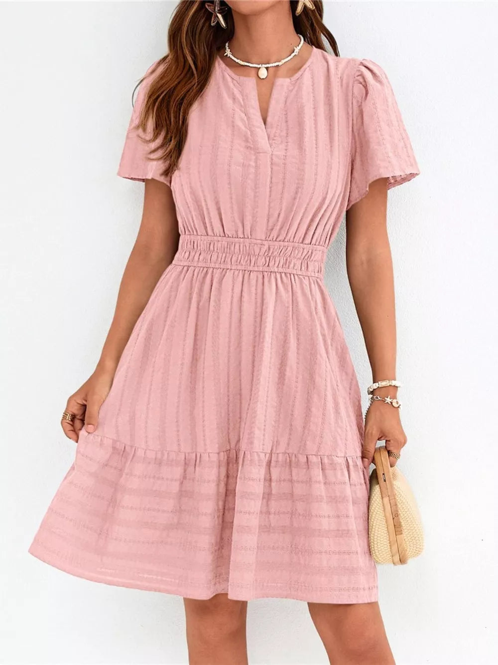 Pink textured V-neck tiered dress with smocked waist and short sleeves