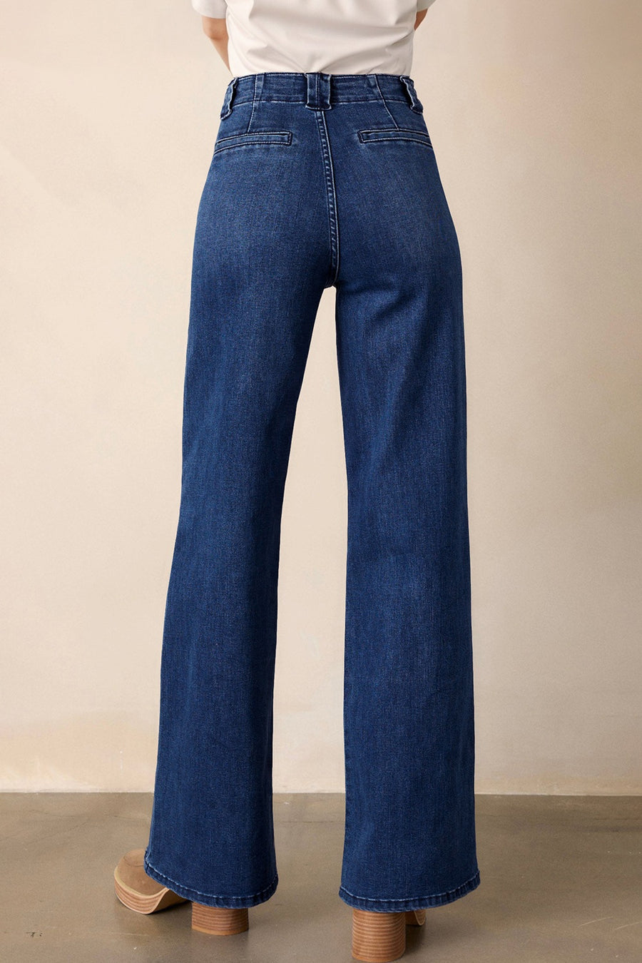 Mid-rise straight leg jeans in dark wash denim with button closure and a wide leg.