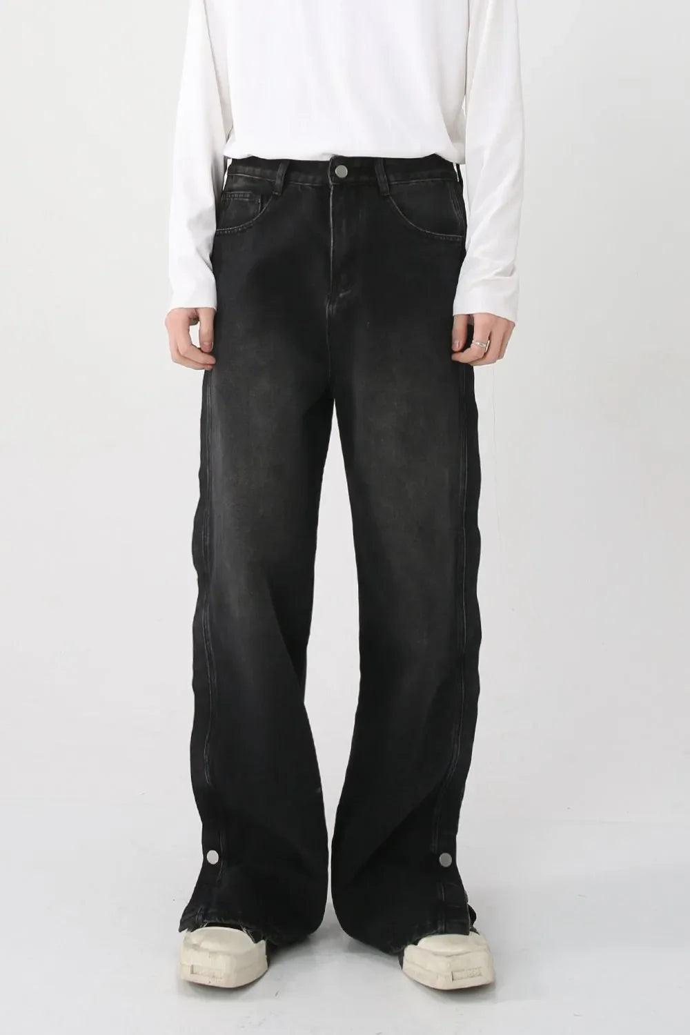 Dark baggy denim jeans with snap hem detail and side slits.
