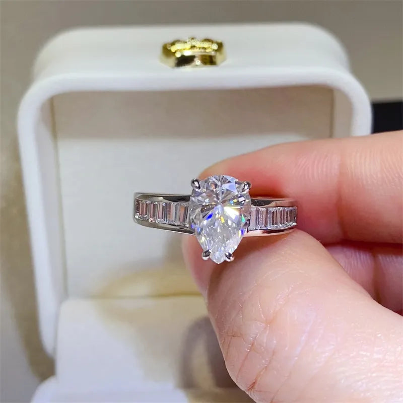 Silver ring with pear cut moissanite and baguette accents