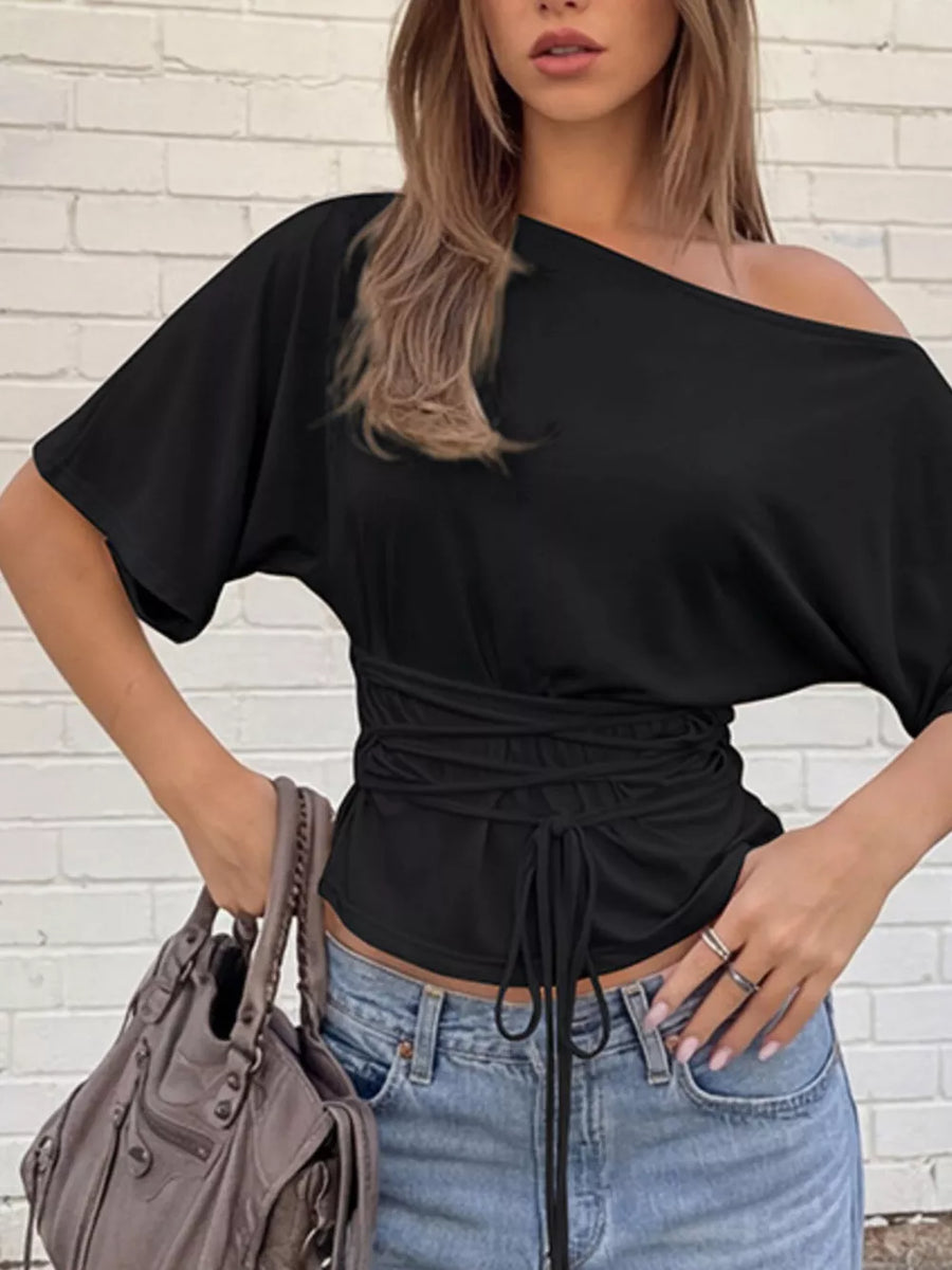 Black draped tie-front short sleeve t-shirt with dolman sleeves and asymmetrical neckline.