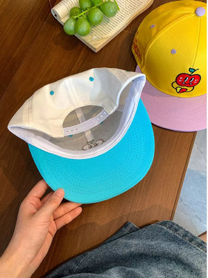 Baseball cap with turquoise brim and white crown embroidered with blue dots.