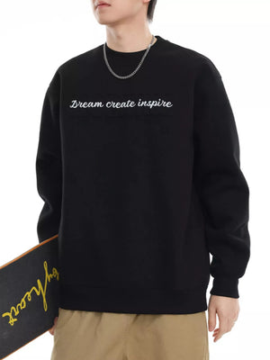 Black oversized crew-neck sweatshirt with embroidered "Dream create inspire" text