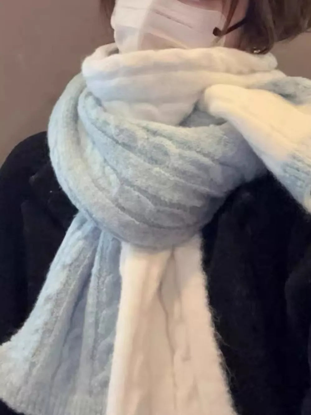 Textured two-tone wool blend scarf in light blue and white with cable knit detail.