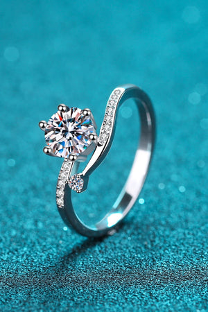 Silver moissanite bypass ring with pavé accents and a round center stone.