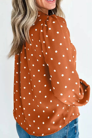Charming polka dot v-neck shirt in rust with white dots, long sleeves, and button detail.