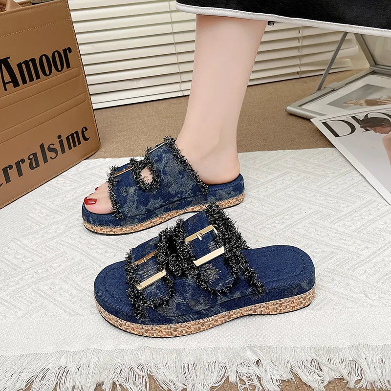 Denim fringe platform slides in navy with gold buckles.