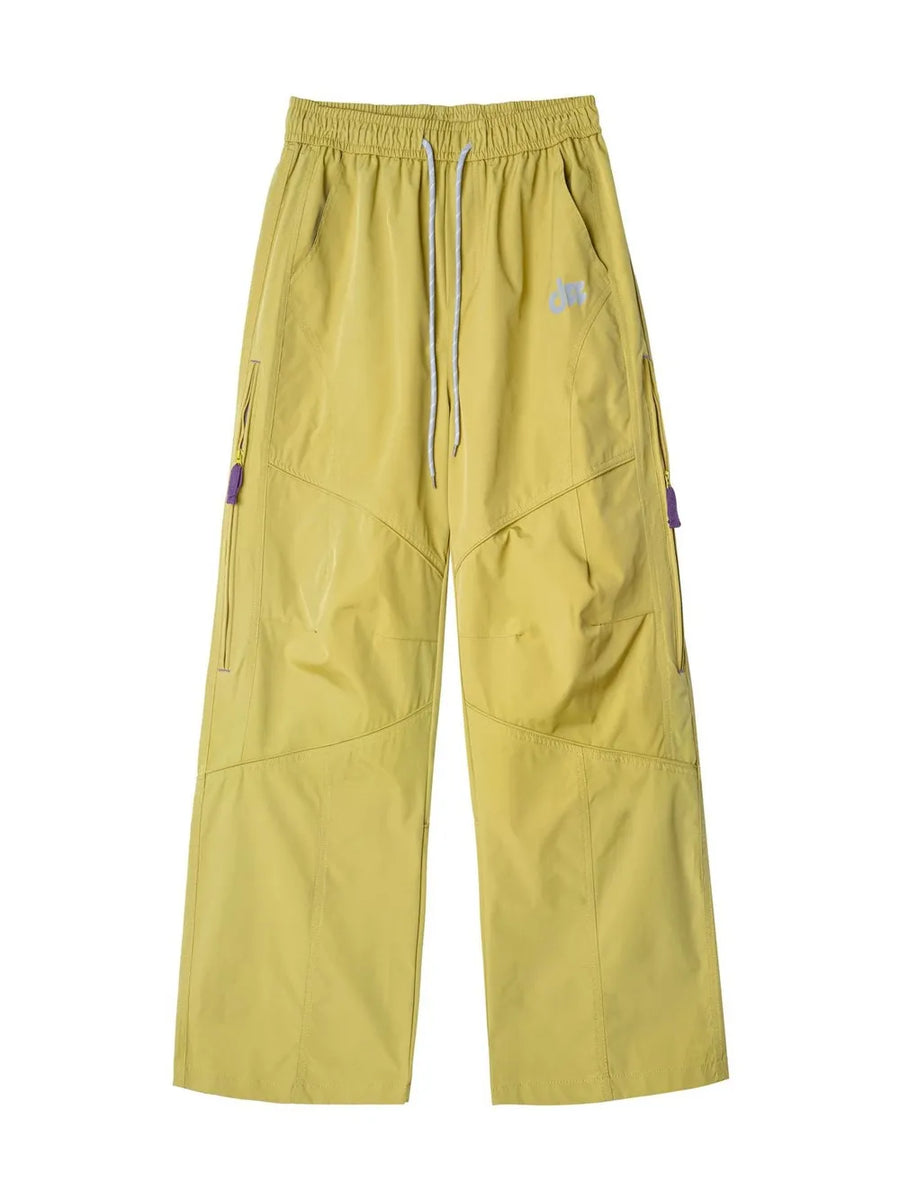 Relaxed fit mustard yellow cargo active pants with drawstring and purple zipper details.
