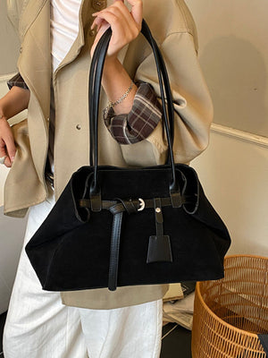 shoulder bag in black featuring decorative buckle and boxy fit