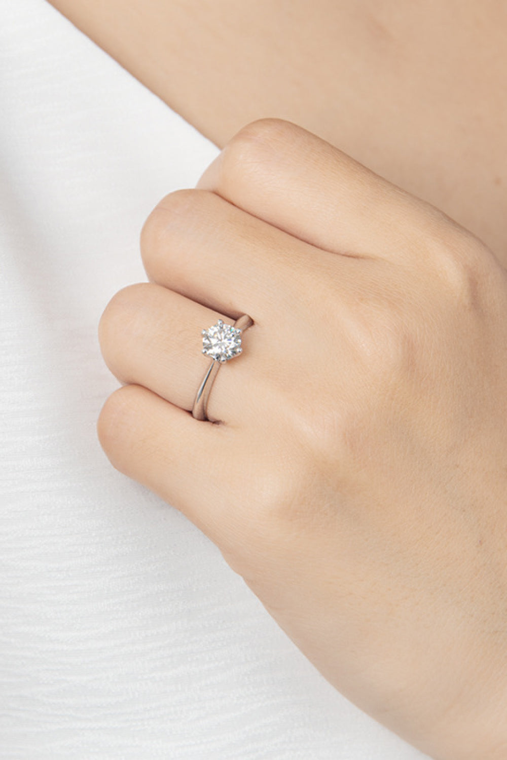 Solitaire moissanite engagement ring in silver with a round brilliant cut stone.