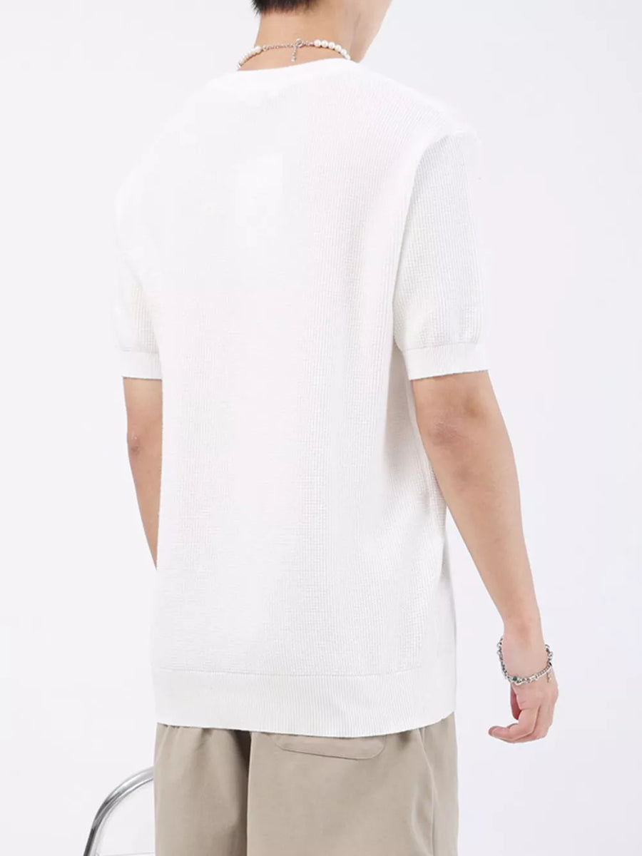Men's white knitted short sleeve henley shirt with a crew neck.
