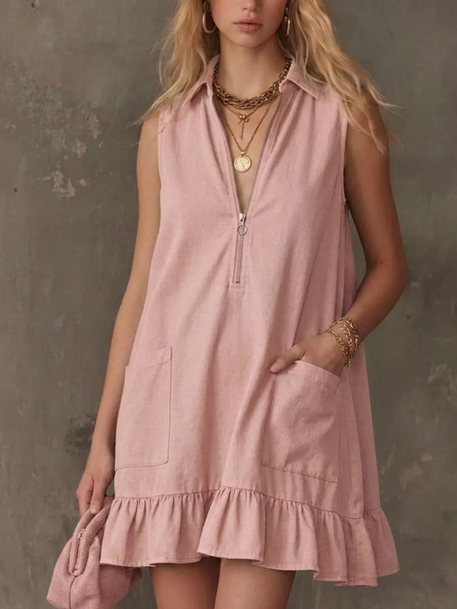 Blush pink sleeveless collared zip-front dress with ruffle hem and pockets.