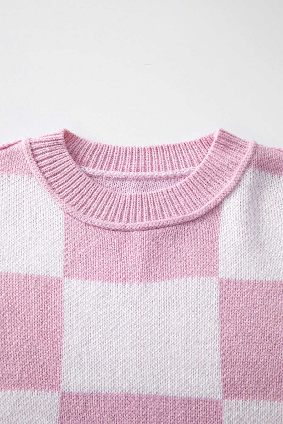 Checkerboard knit crewneck sweater in Dusty Pink and white acrylic with ribbed neckline.