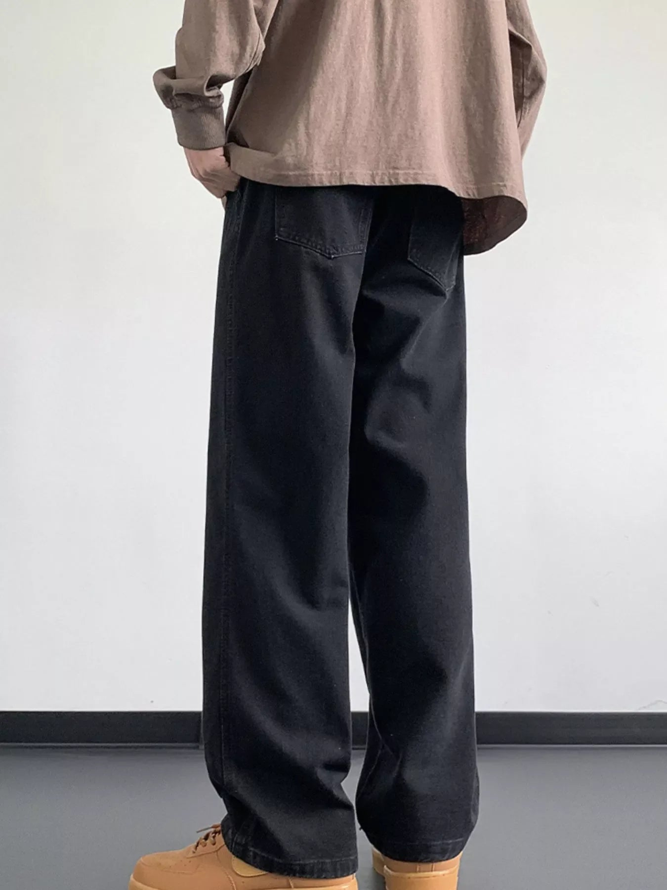 Black oversized drawstring jeans with a loose fit and back pockets.