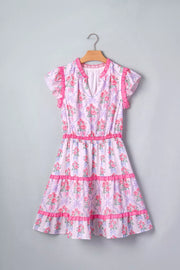 Floral tiered ruffle dress with pink roses and blue bows on a light pink background.