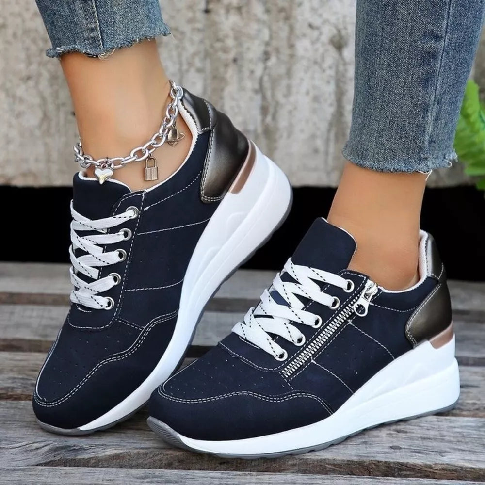 Navy lace-up wedge sneakers with side zipper and metallic heel detail.