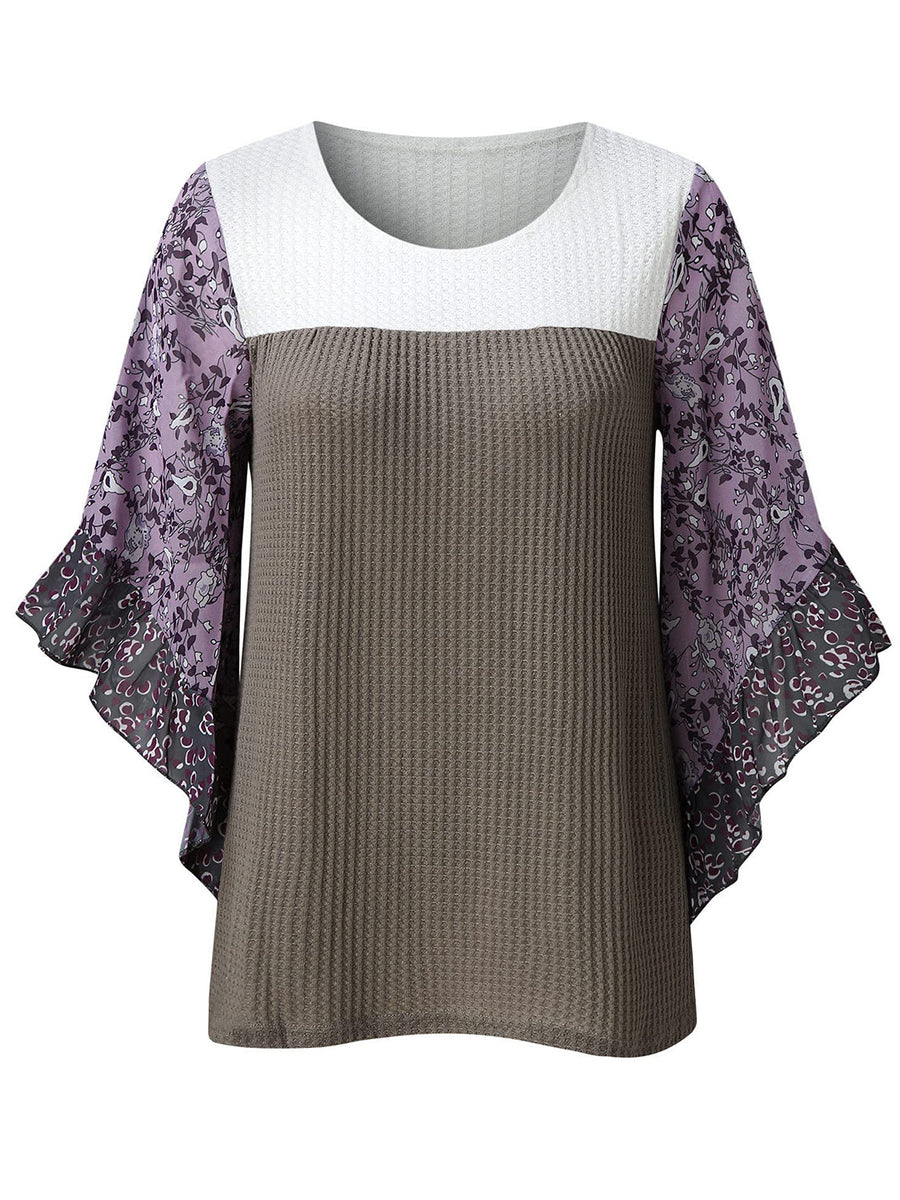 Textured panel blouse with white and gray waffle knit body and purple floral flutter sleeves.