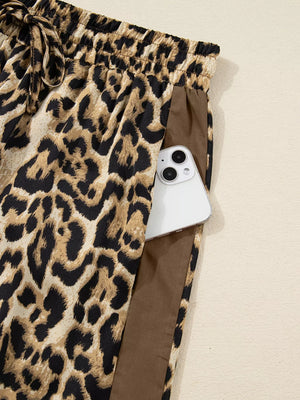 Leopard print two-piece set pants with drawstring waist and side pocket holding a phone.