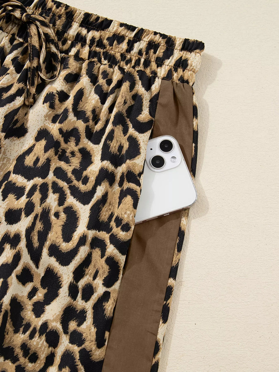 Leopard print two-piece set pants with drawstring waist and side pocket holding a phone.