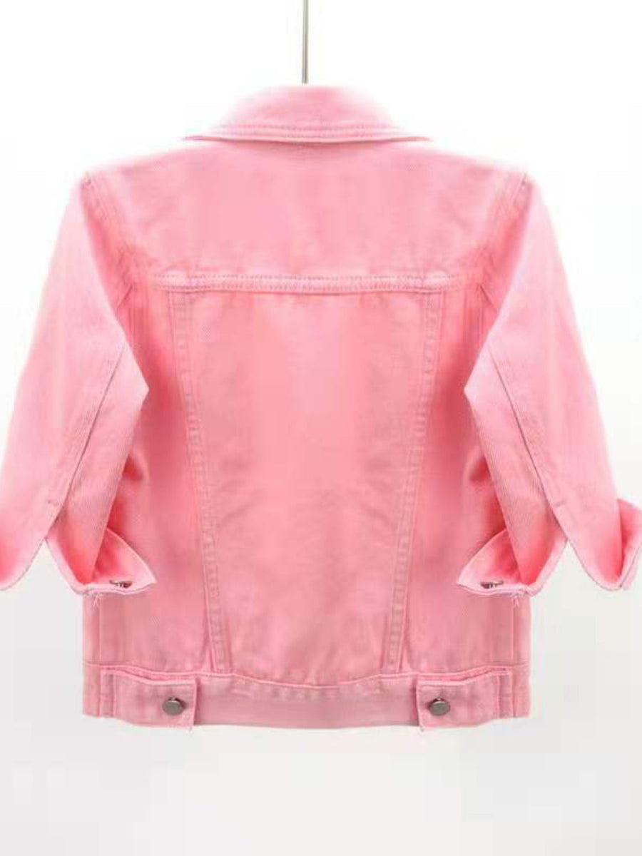 Pink denim trucker jacket with cropped sleeves and rolled cuffs.