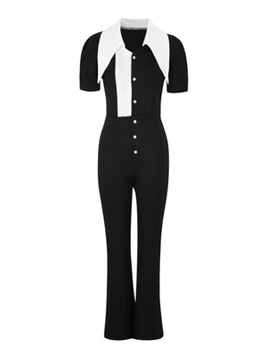 Button-down wide leg jumpsuit in black and white with short sleeves and a dramatic collar.