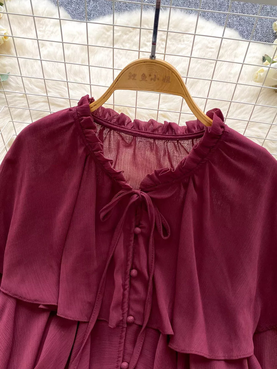 Red chiffon blouse with ruffled neckline, bow tie, and button front.