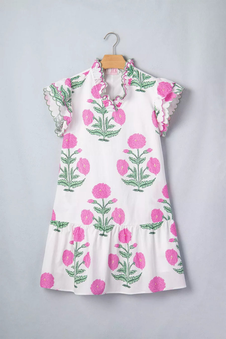 White mini dress with vibrant pink floral print, ruffled neckline and sleeves.